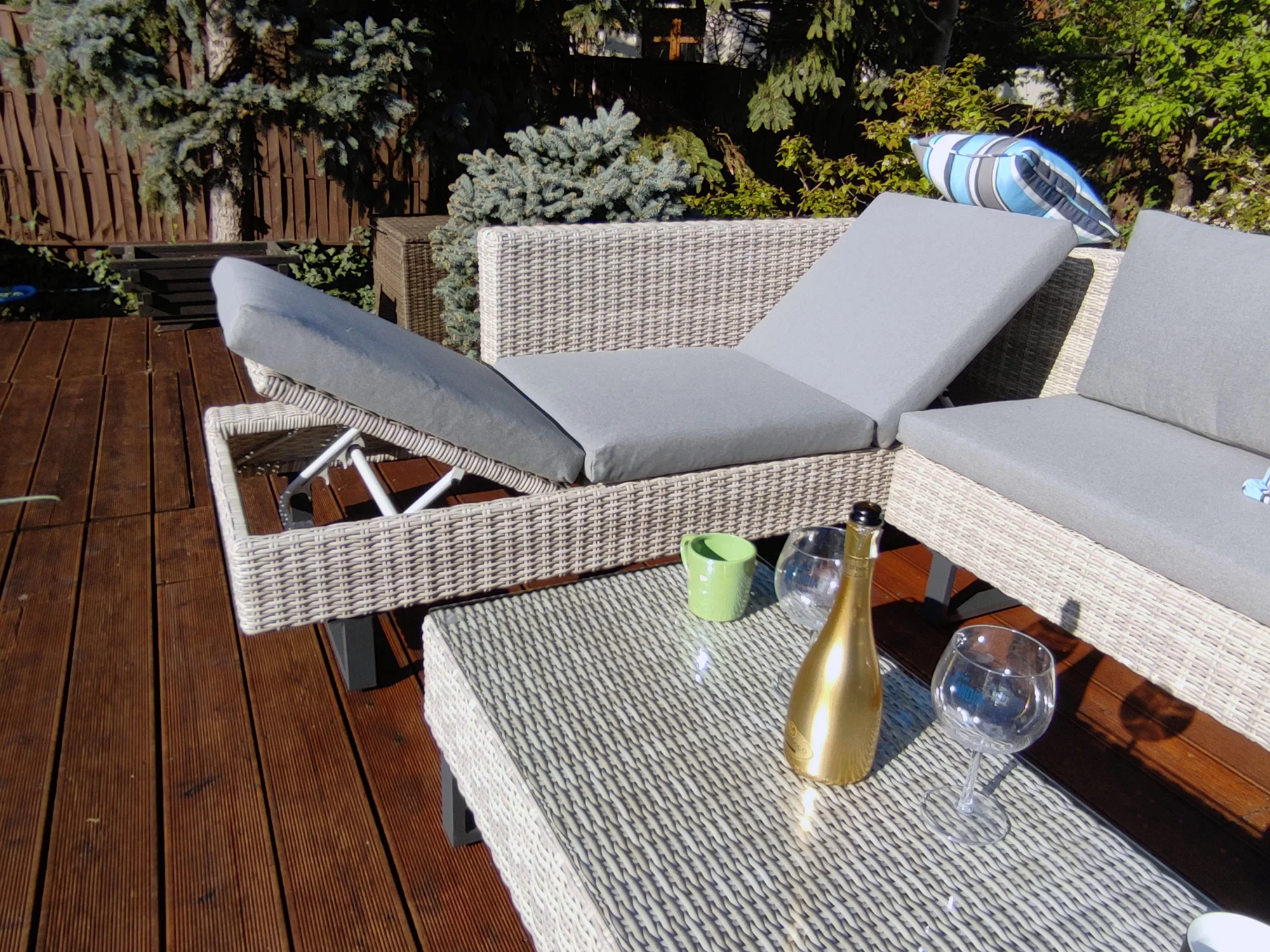 Narożnik PINETO jasno-szary na drewnianym tarasie — poduszki szare, dekoracje