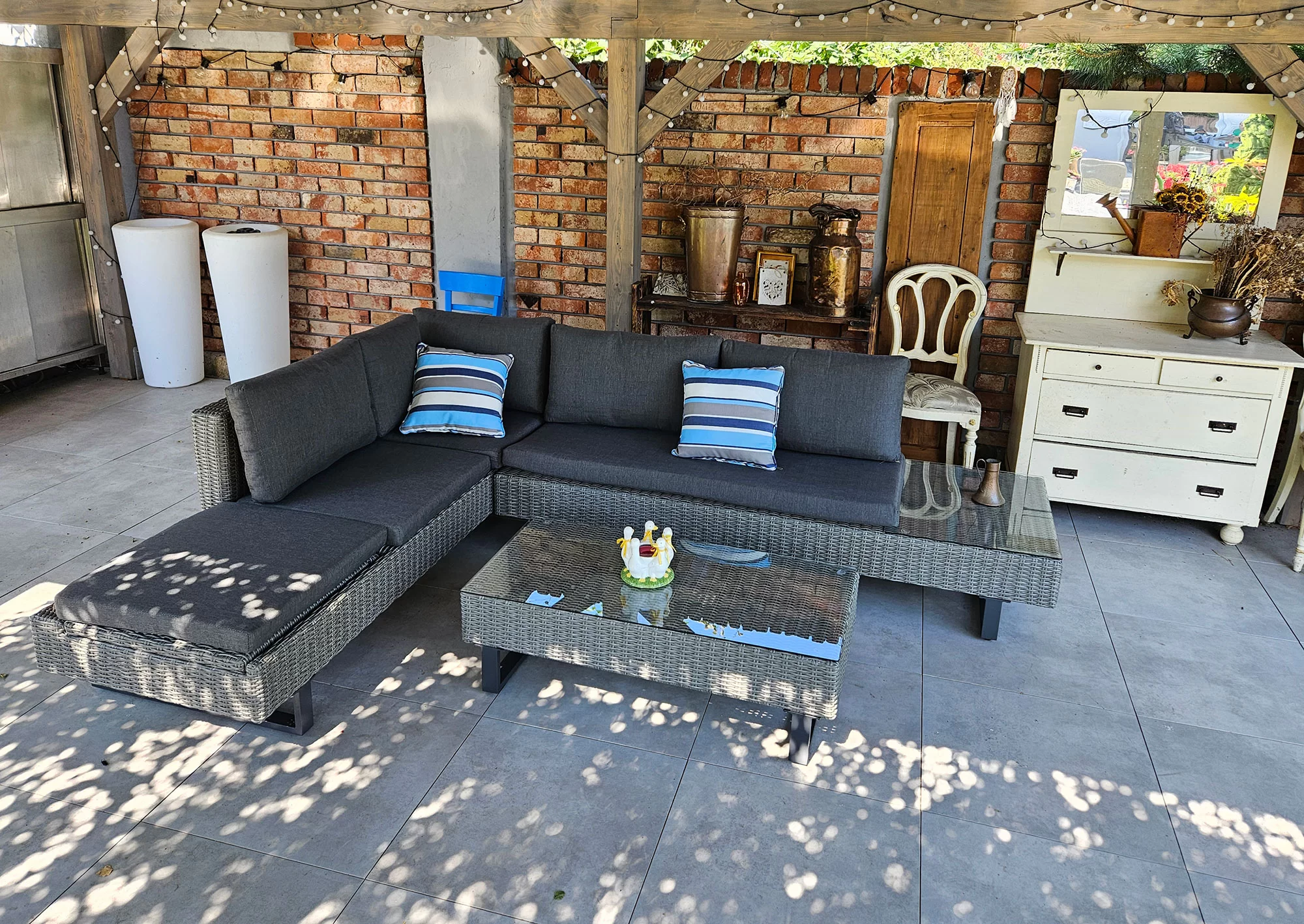 Narożnik PINETO szary — szeroki widok frontalny pod pergolą z komodą vintage