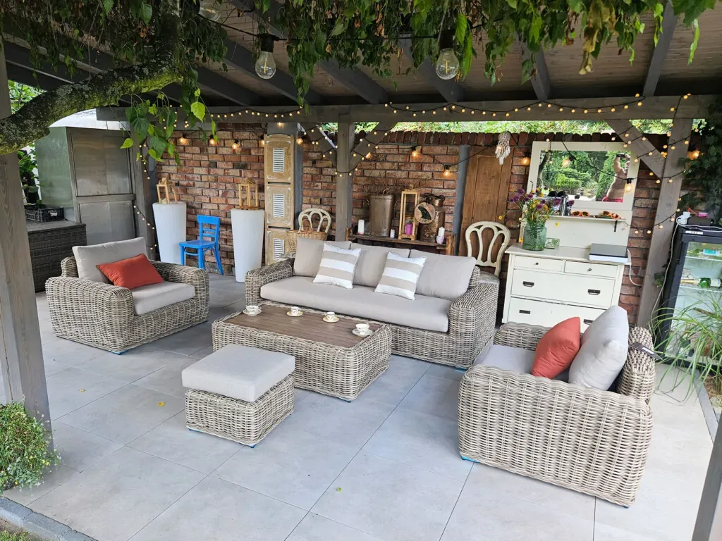 Zestaw ogrodowy TOSCANIA — sofa i fotele na tarasie z ceglaną ścianą