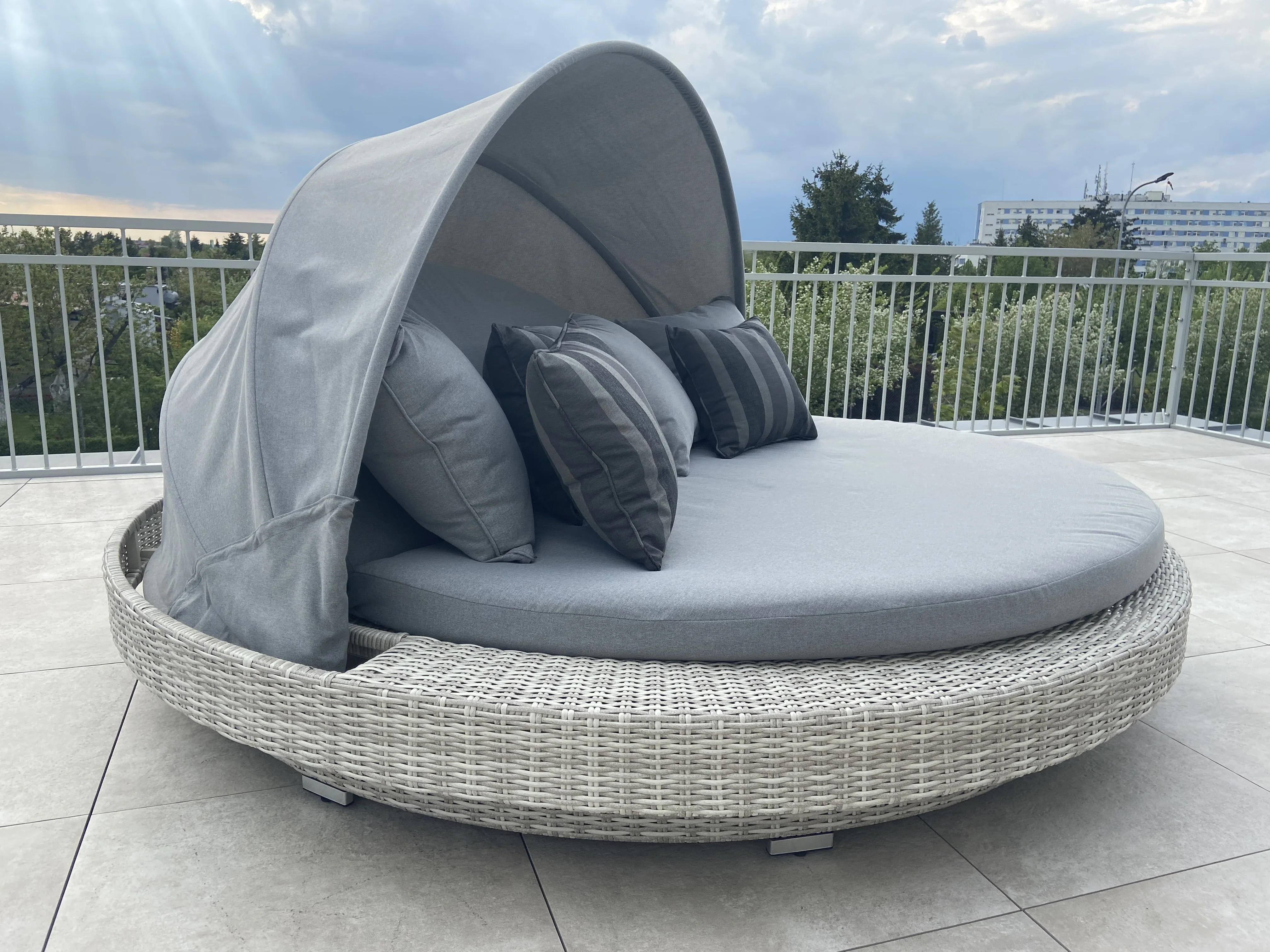Okrągła leżanka ogrodowa SANTORINI z baldachimem — realizacja na balkonie apartamentu, widok na miasto